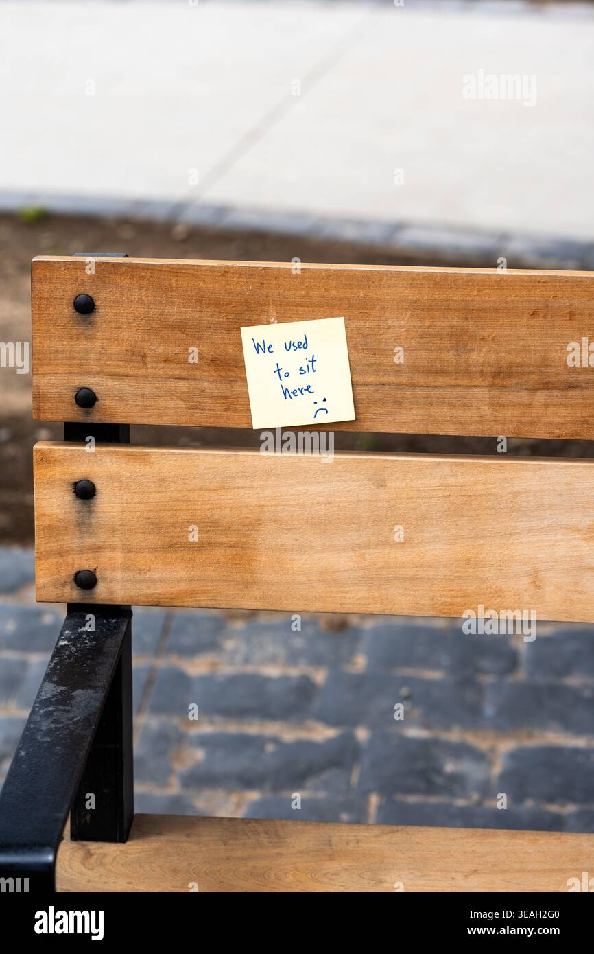 "Ci sedevamo qui" Nota scritta a mano su una panchina in legno che simboleggia la memoria e la Nostalgia Foto Stock