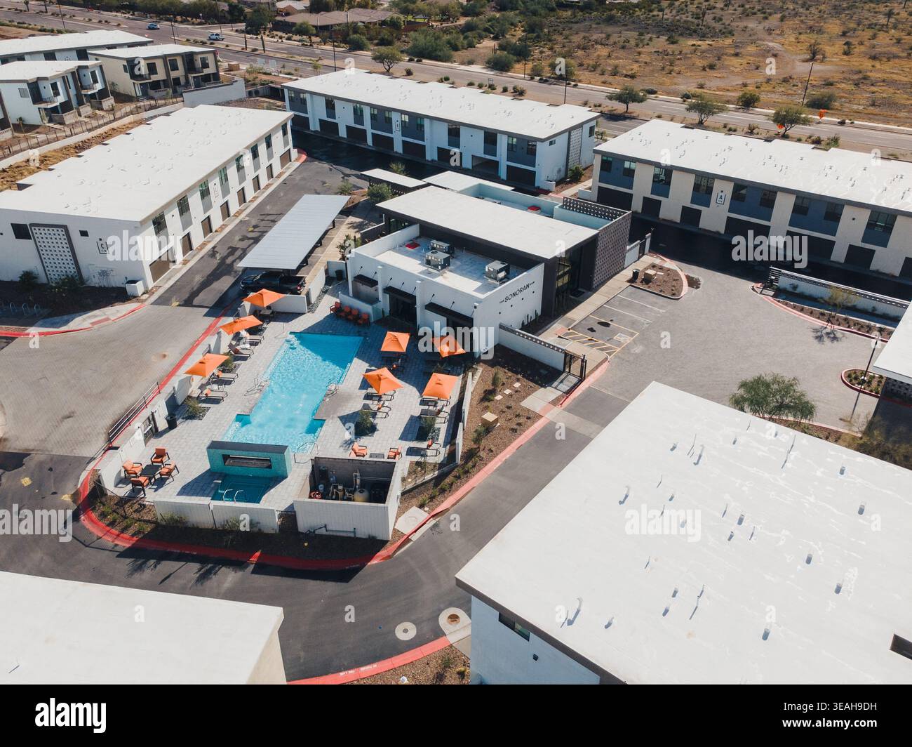 Panoramica delle scenografie di pool. Vista ad alto angolo della piscina per il tempo libero circondata da appartamenti. Foto dall'alto che mostra un'ambientazione glamour a bordo piscina con Foto Stock