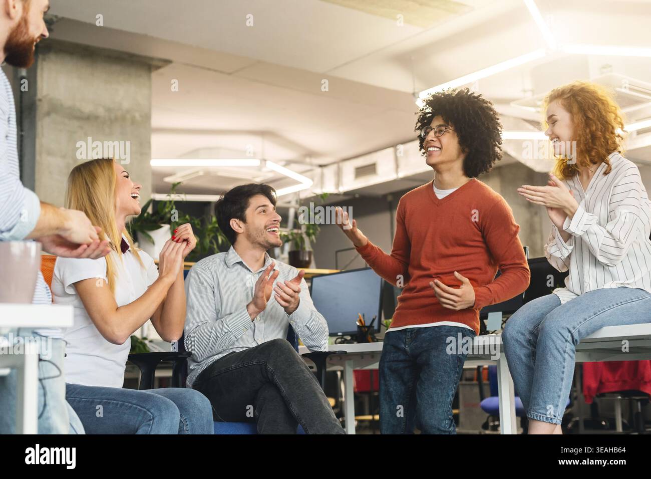 Il team Creative godendo la comunicazione in ufficio moderno Foto Stock