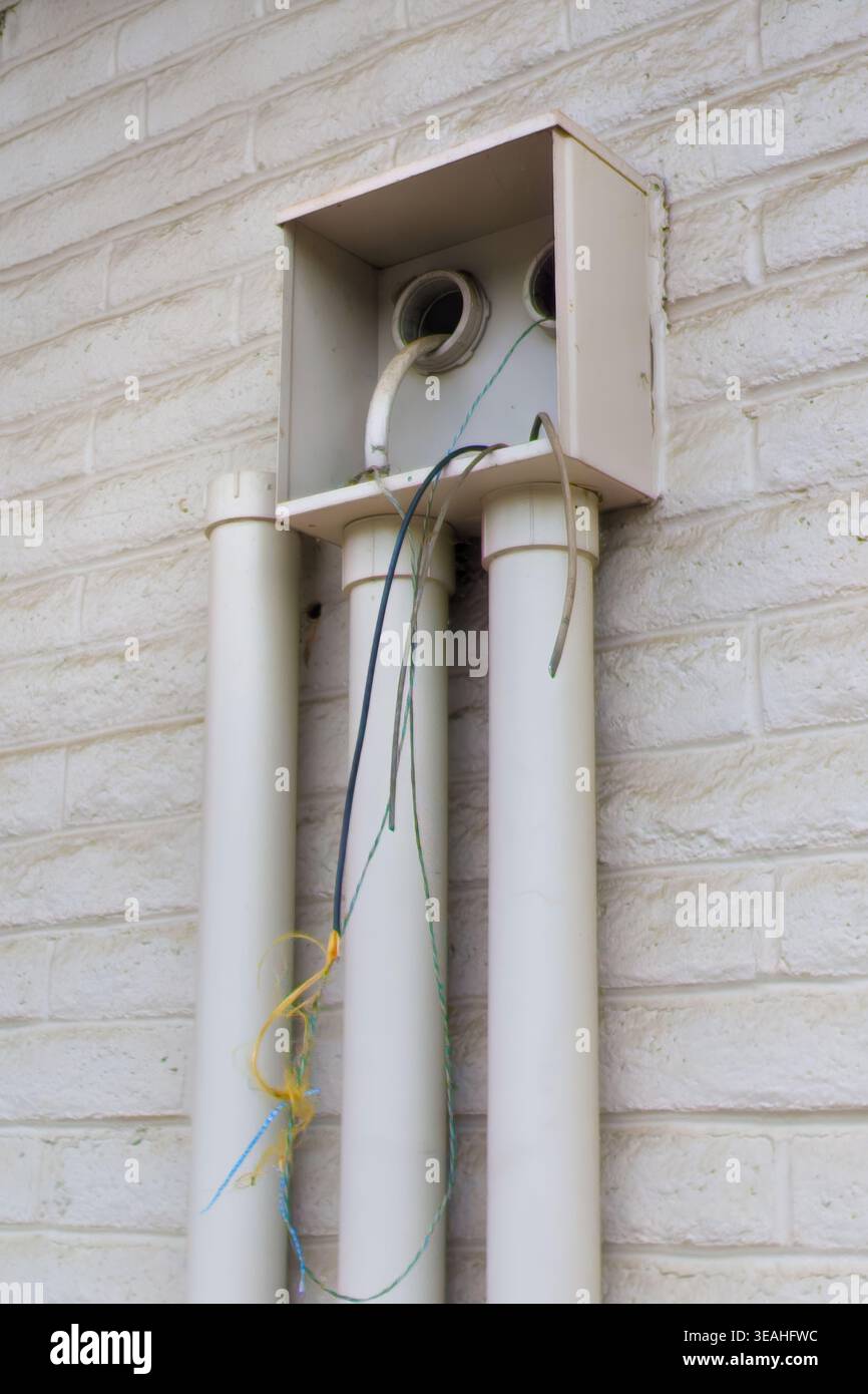 Condotto elettrico esposto con cablaggio in rame mancante che mostra danni da furto all'infrastruttura Foto Stock