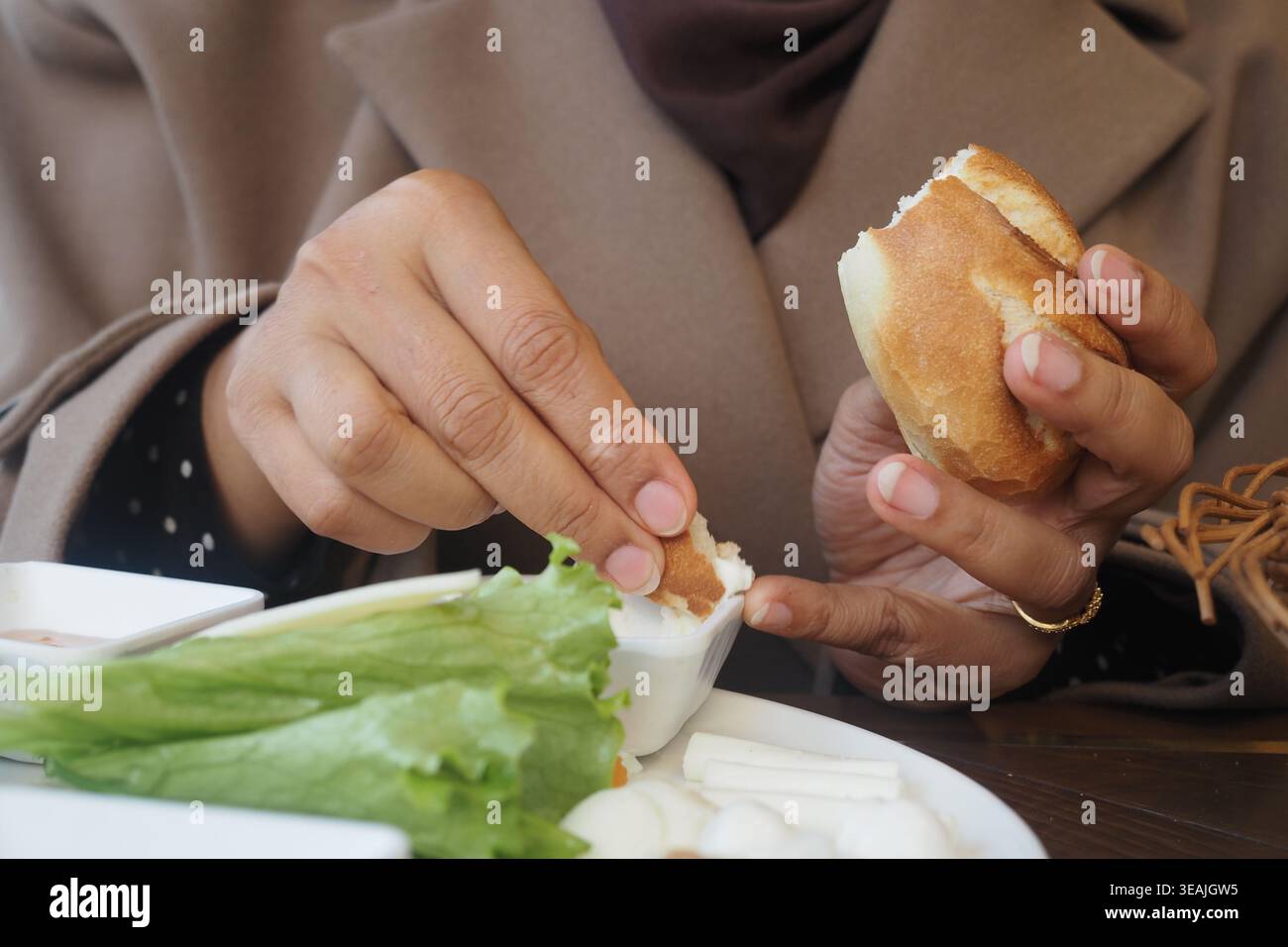 Le mani possono gustare il cibo a un tavolo in un ambiente informale Foto Stock