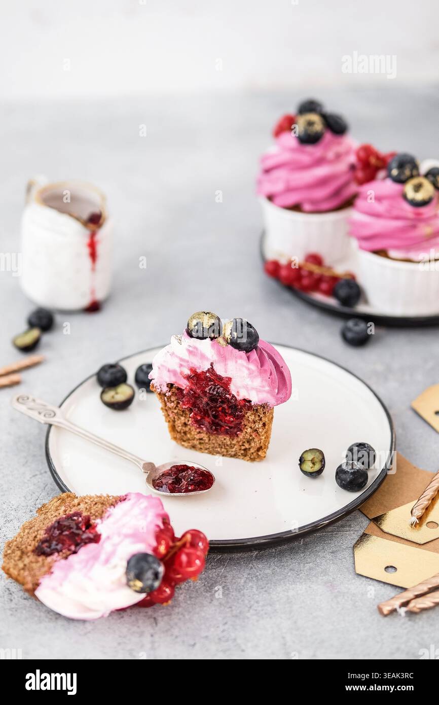 Elegante brunch con Cupcake decorati con frutti di bosco ed elementi con rivestimento leggero Foto Stock
