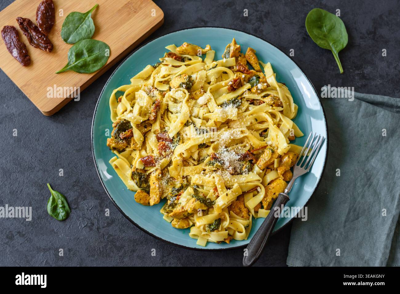 Pasta con pollo, spinaci e pomodori secchi in salsa di curcuma Foto Stock