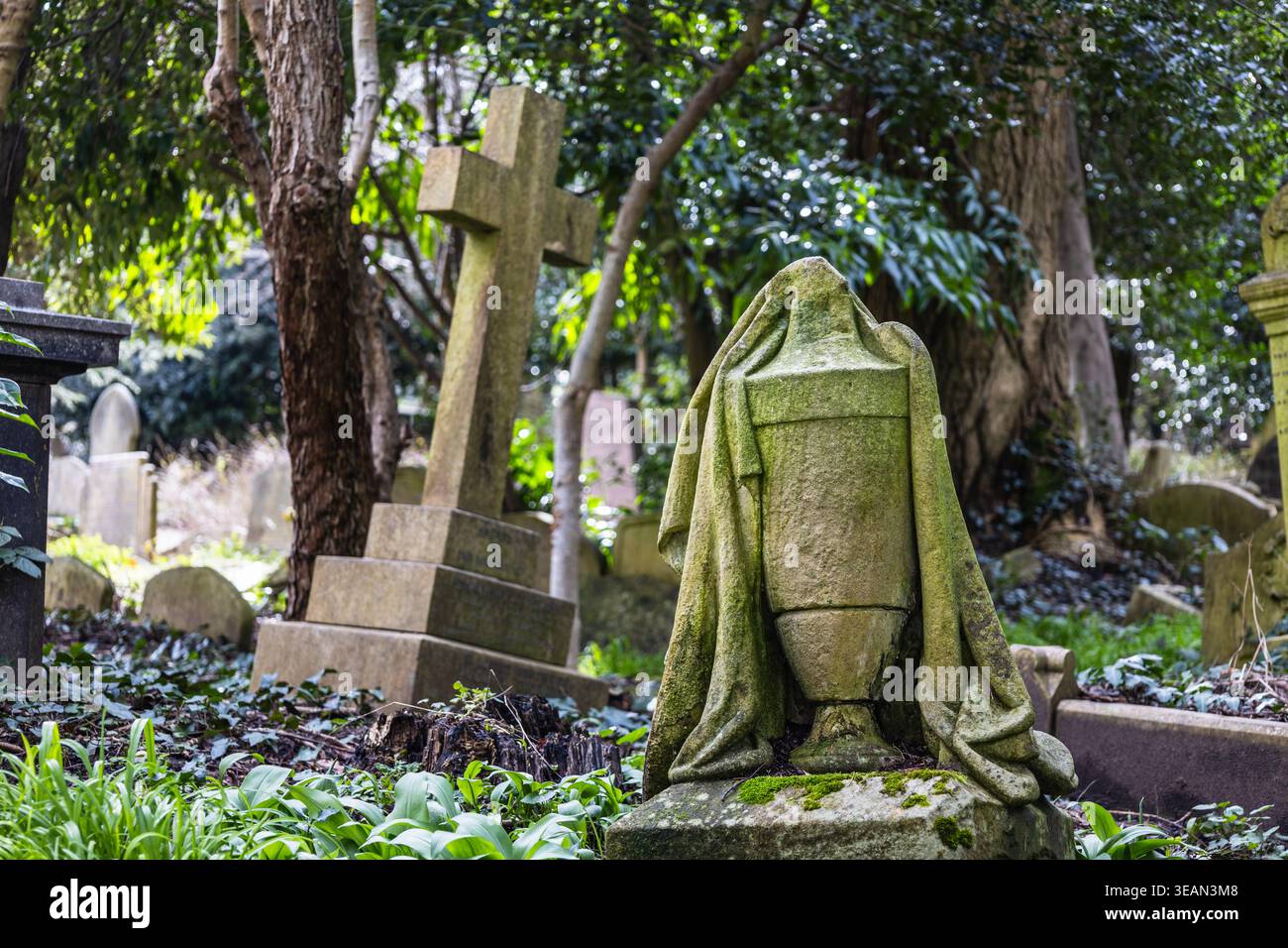 Moss ha coperto l'urna e la croce al cimitero di Highgate a Londra Foto Stock