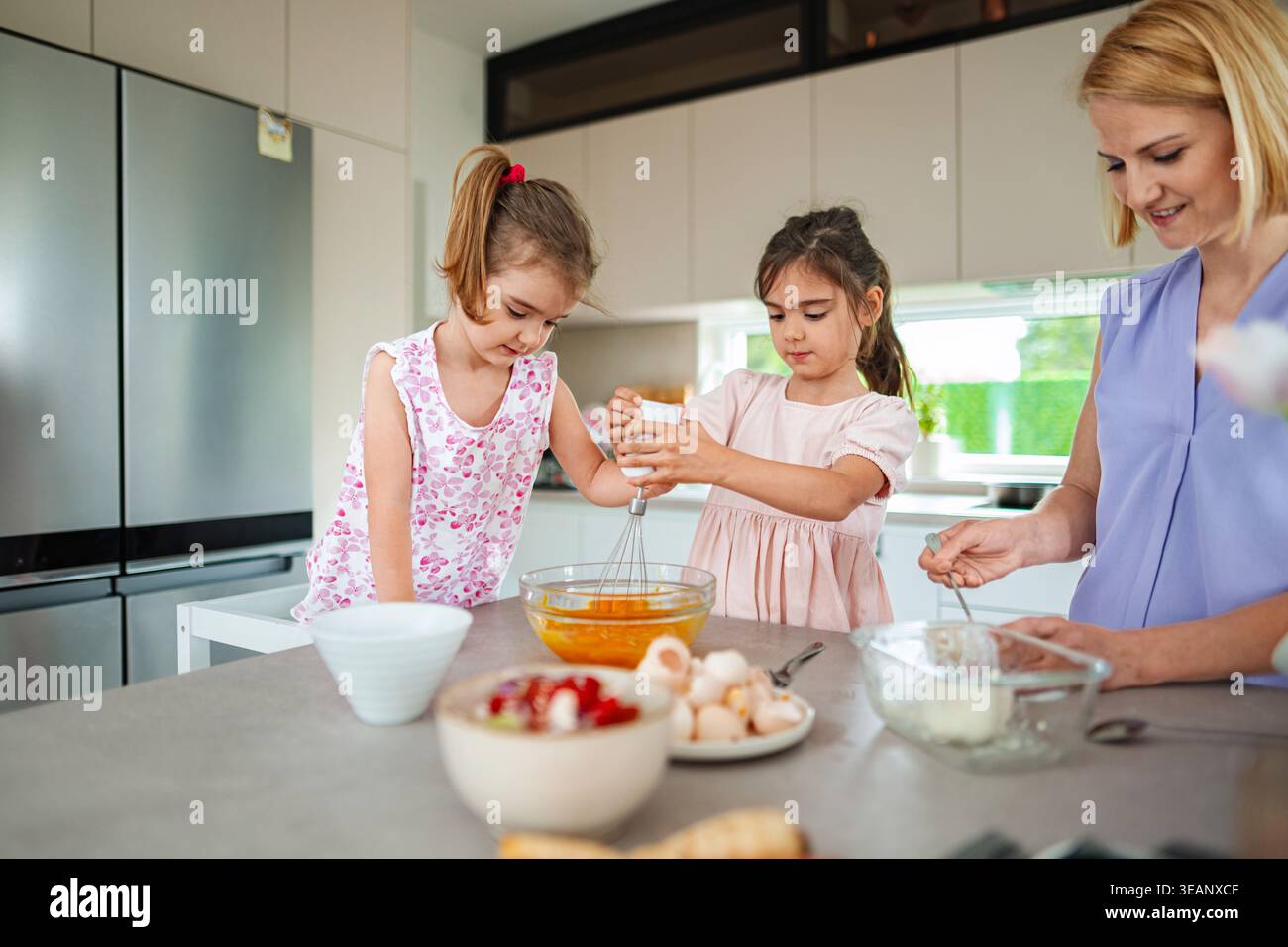 Le sorelle si divertono a fare un delizioso regalo con la madre Foto Stock