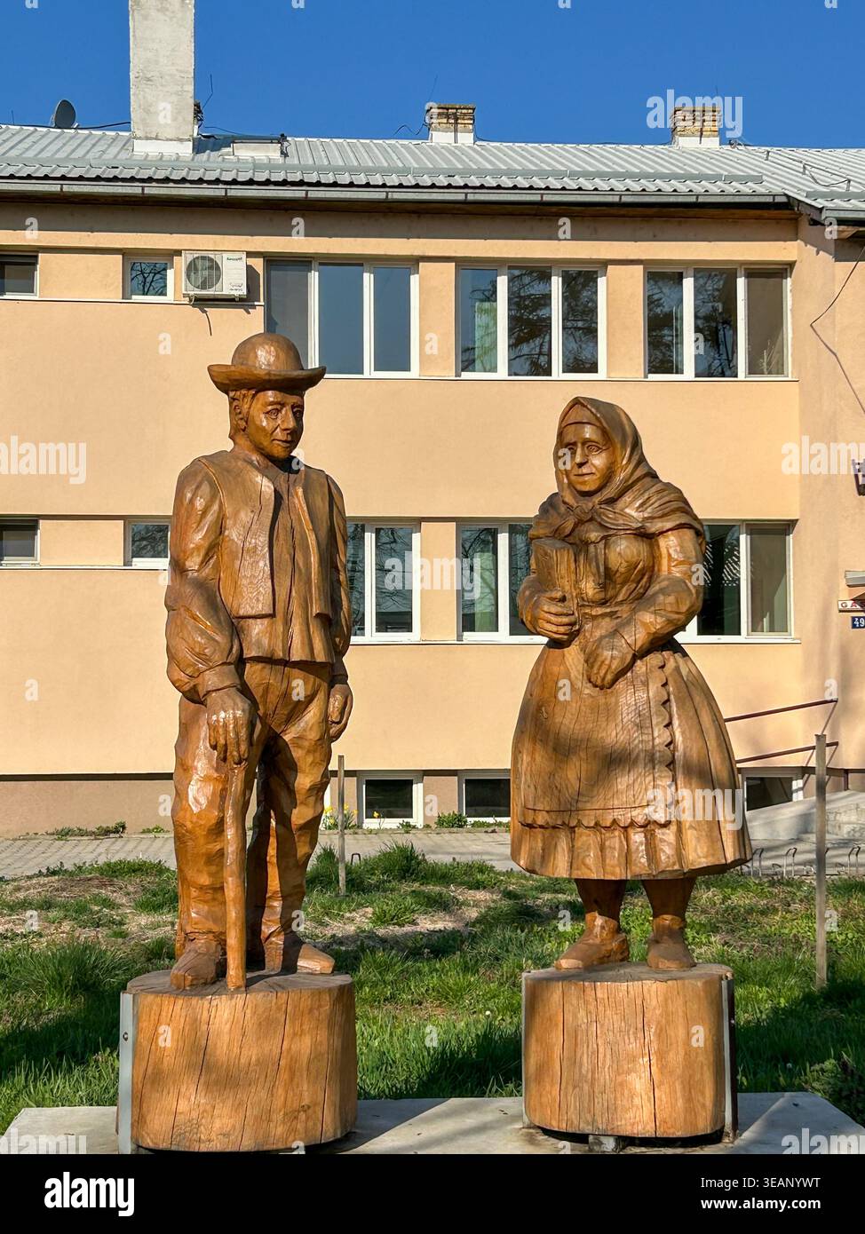 Sculture in legno di un uomo e di una donna in costumi tradizionali slovacchi, che rappresentano il patrimonio culturale di Kisač, Serbia. - Immagine stock catturata con smartphone