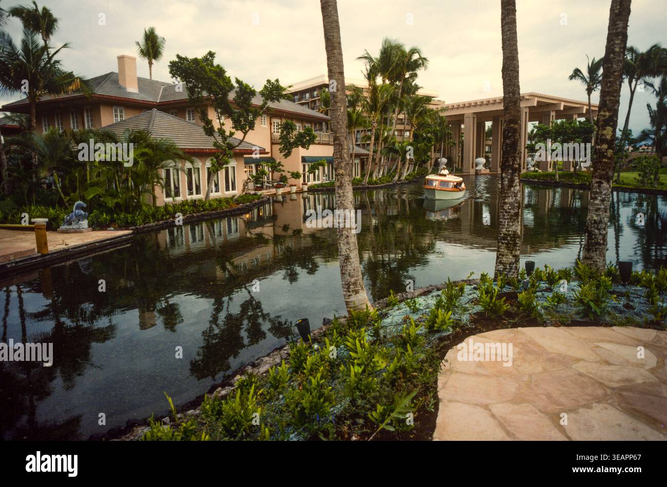 Gli ospiti dell'hotel sono trasportati attraverso i giardini da barche che corrono su piste sotto il livello dell'acqua in un hotel di lusso sull'isola di Maui, Hawaii, Stati Uniti Foto Stock