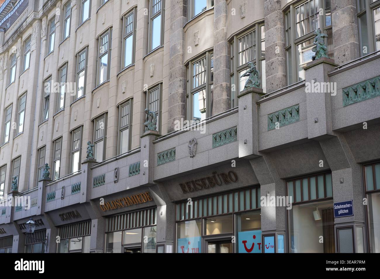 Berlino, Germania - 23 aprile 2026: La facciata al piano terra di Spks Hof a Schuhmachergäßchen, con negozi locali e sculture storiche in bronzo. Foto Stock
