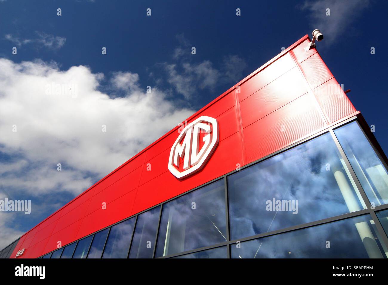 uno showroom di auto mg con cielo blu e nuvole bianche sullo sfondo Foto Stock
