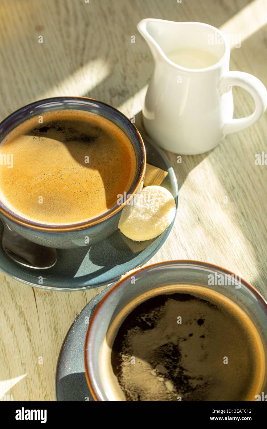 Primo piano di un caffè e di un biscotto su un tavolo Foto Stock
