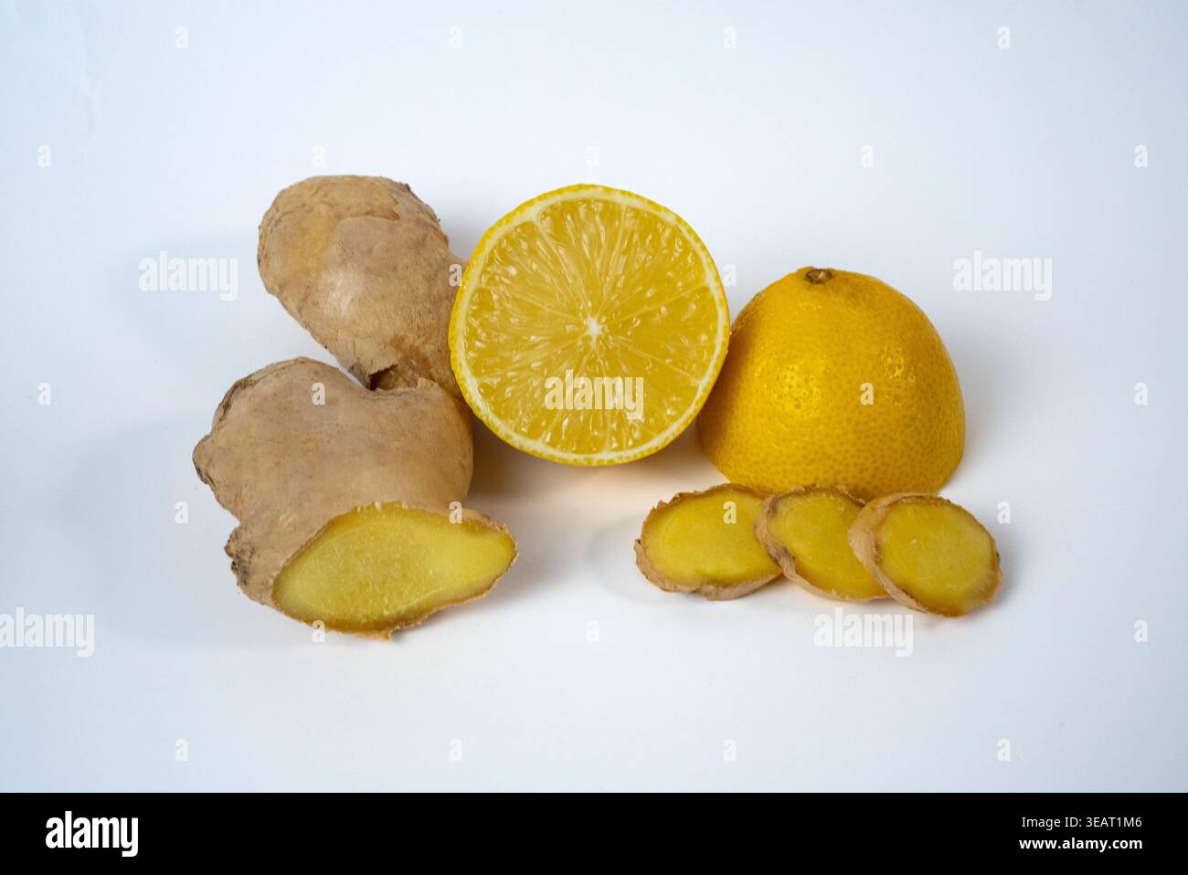 Limone fresco e radice di zenzero isolati su bianco. Ingredienti naturali per bevande salutari e concetti di benessere. Foto Stock