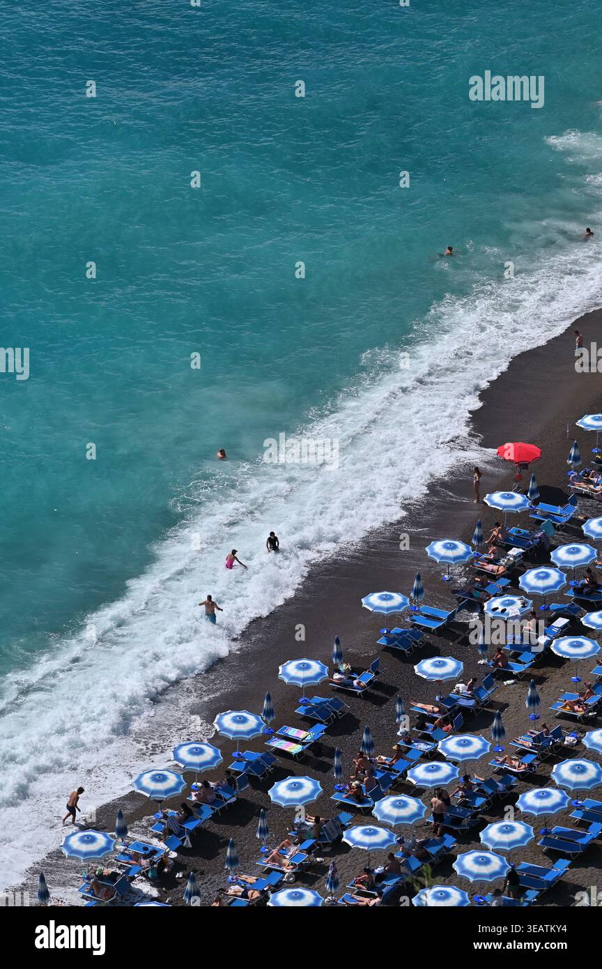 Ombrelloni e onde a Spiaggia grande a Positano, Costiera Amalfitana, Italia Foto Stock