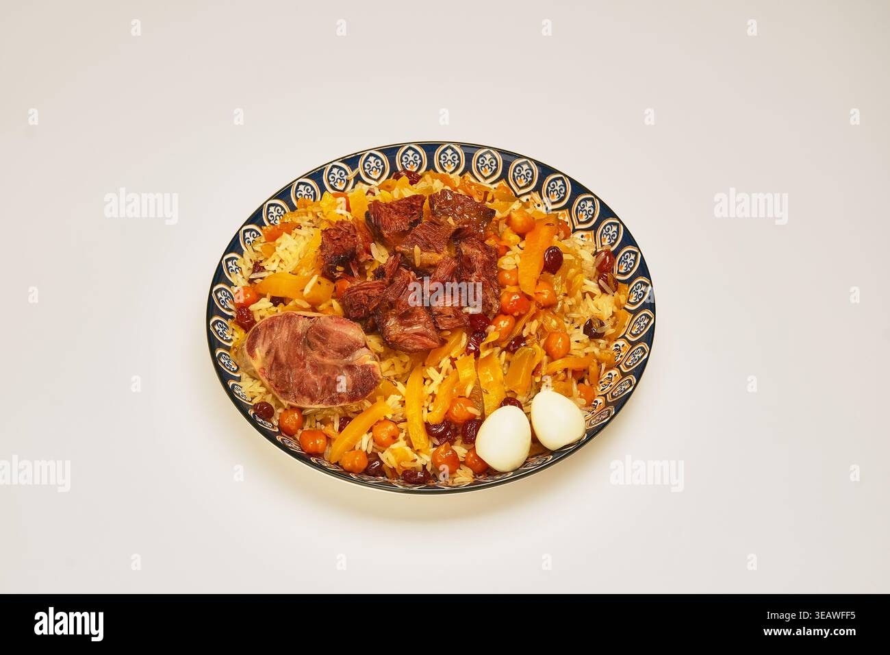 Squisito pilaf di agnello in stile chef guarnito elegantemente con uova di quaglia Foto Stock