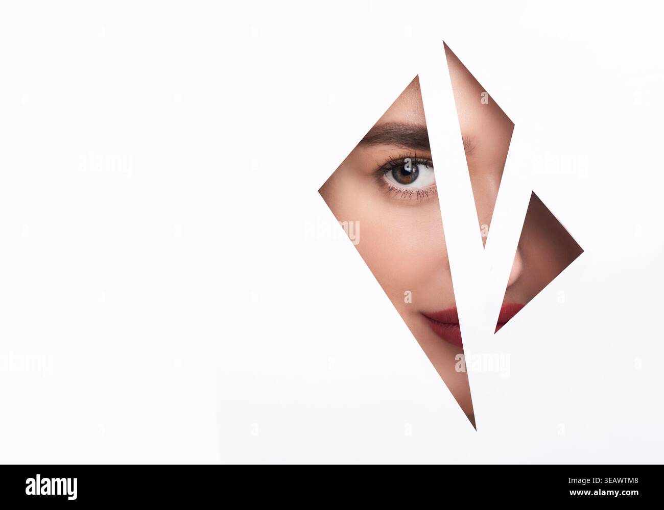 Collage di un volto femminile visto attraverso una forma ritagliata con una messa a fuoco su un occhio e parte delle sue labbra Foto Stock