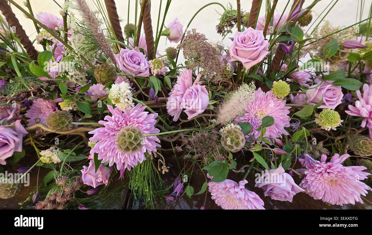 Primo piano di una composizione floreale a tema primaverile in sfumature lilla, perfetta per matrimoni. - Immagine stock catturata con smartphone