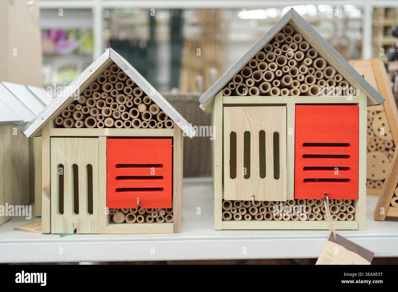 Hotel decorativi per insetti con pannelli colorati esposti in negozio. Progettato per attirare insetti benefici e sostenere l'equilibrio ecologico. Foto Stock