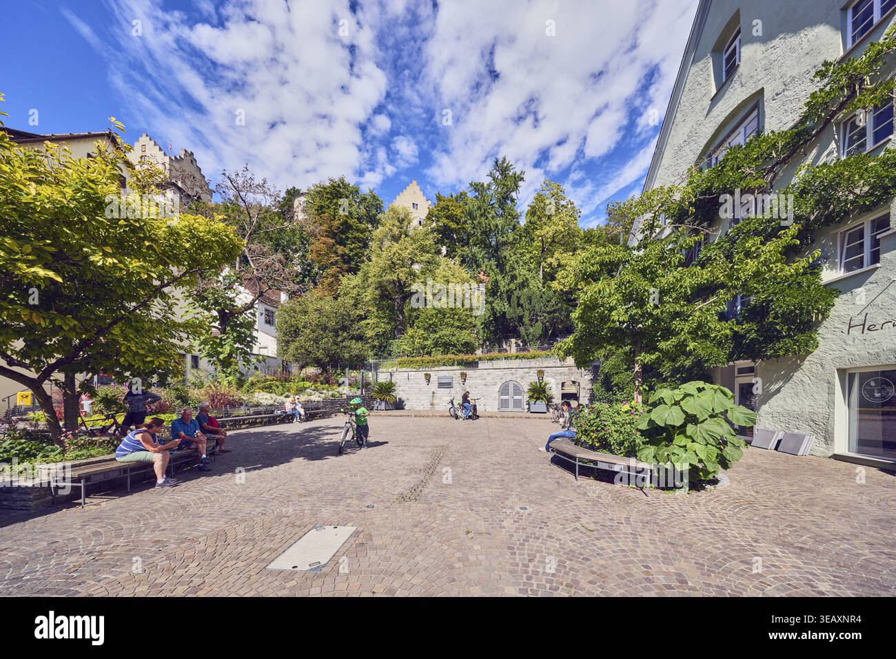Quadrato, architettura generale, panchine, posti a sedere pubblici, persone sedute come motivo secondario, alberi, cespugli, cielo blu, nuvole di cumulus, Unterstadtstr Foto Stock