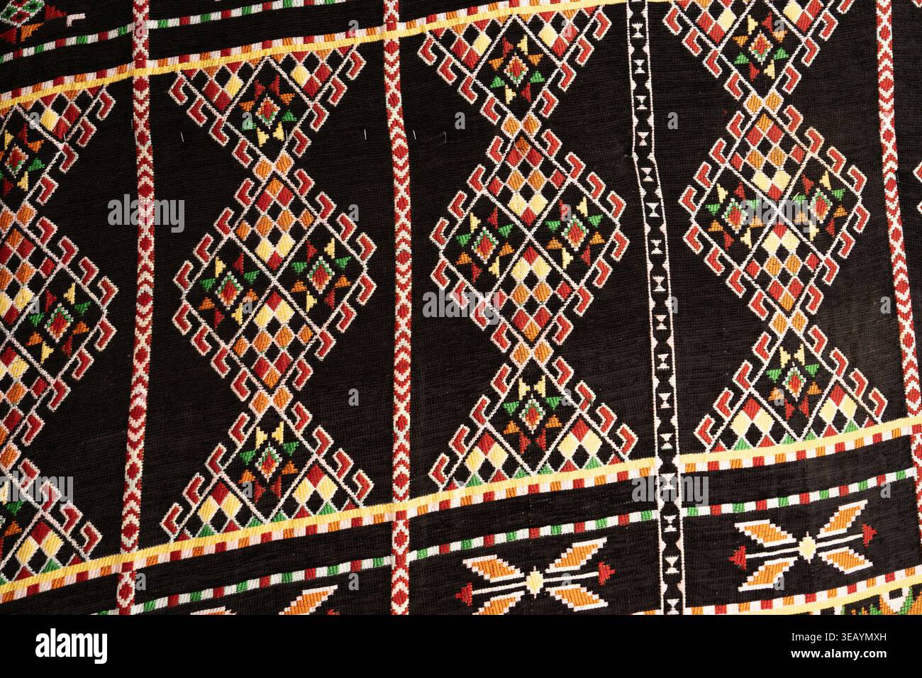 Tessuti beduini egiziani che mostrano tradizionali motivi etnici e disegni geometrici, con ricami colorati che creano un ricco sfondo culturale Foto Stock