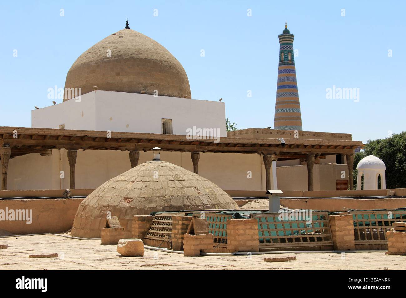 Strutture storiche all'interno della fortezza di Khiva. Le decorazioni in mattoni e piastrelle sugli edifici a cupola sono degne di nota. Foto Stock
