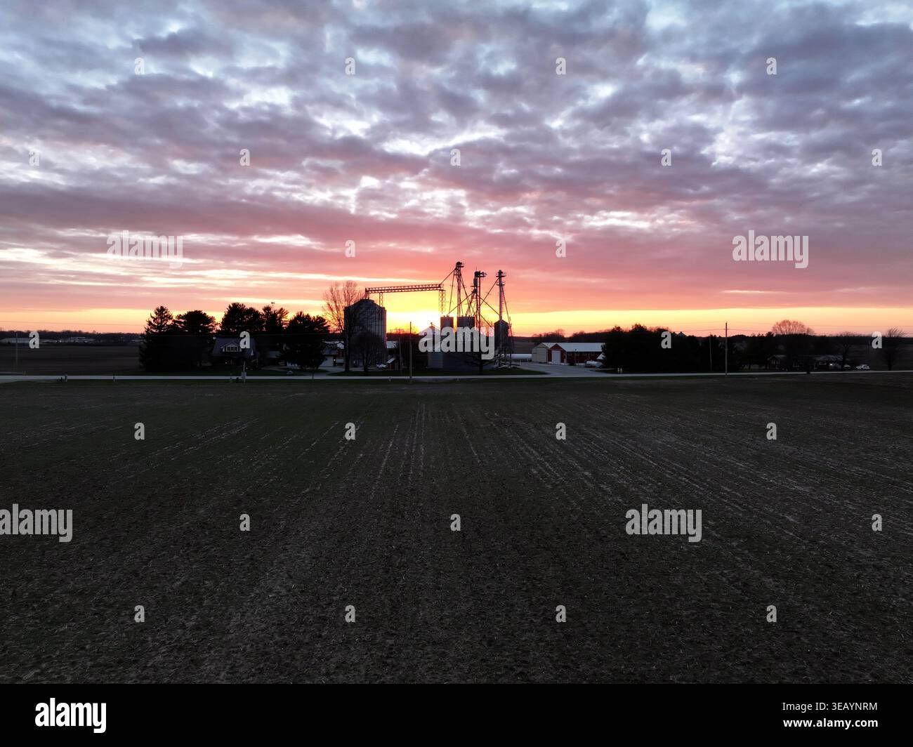 Vista aerea della luce dorata del sole che baciano l'orizzonte sugli elevatori e i campi di grano sagomati al crepuscolo, Cincinnati, Ohio, Stati Uniti. Foto Stock
