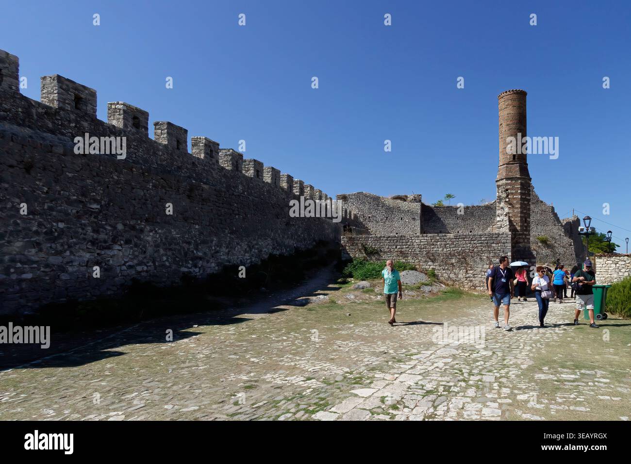 I turisti camminano attraverso le storiche mura di pietra e il minareto della Moschea Rossa al Castello di Berat in Albania Foto Stock