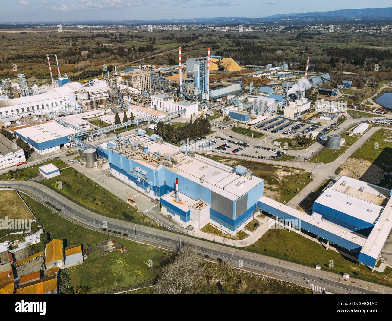 Veduta aerea di un vasto complesso industriale con edifici bianchi in contrasto con il lussureggiante paesaggio verde, Cacia, il quartiere di Aveiro, Portogallo. Foto Stock