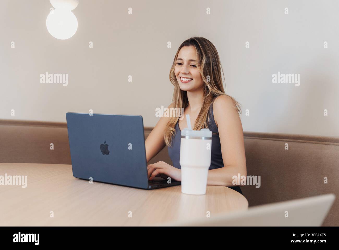 Donna che usa il computer pacificamente. Giovane donna in un ambiente tranquillo che utilizza il suo notebook con attenzione. Giovane donna che lavora tranquillamente sul suo notebook Foto Stock