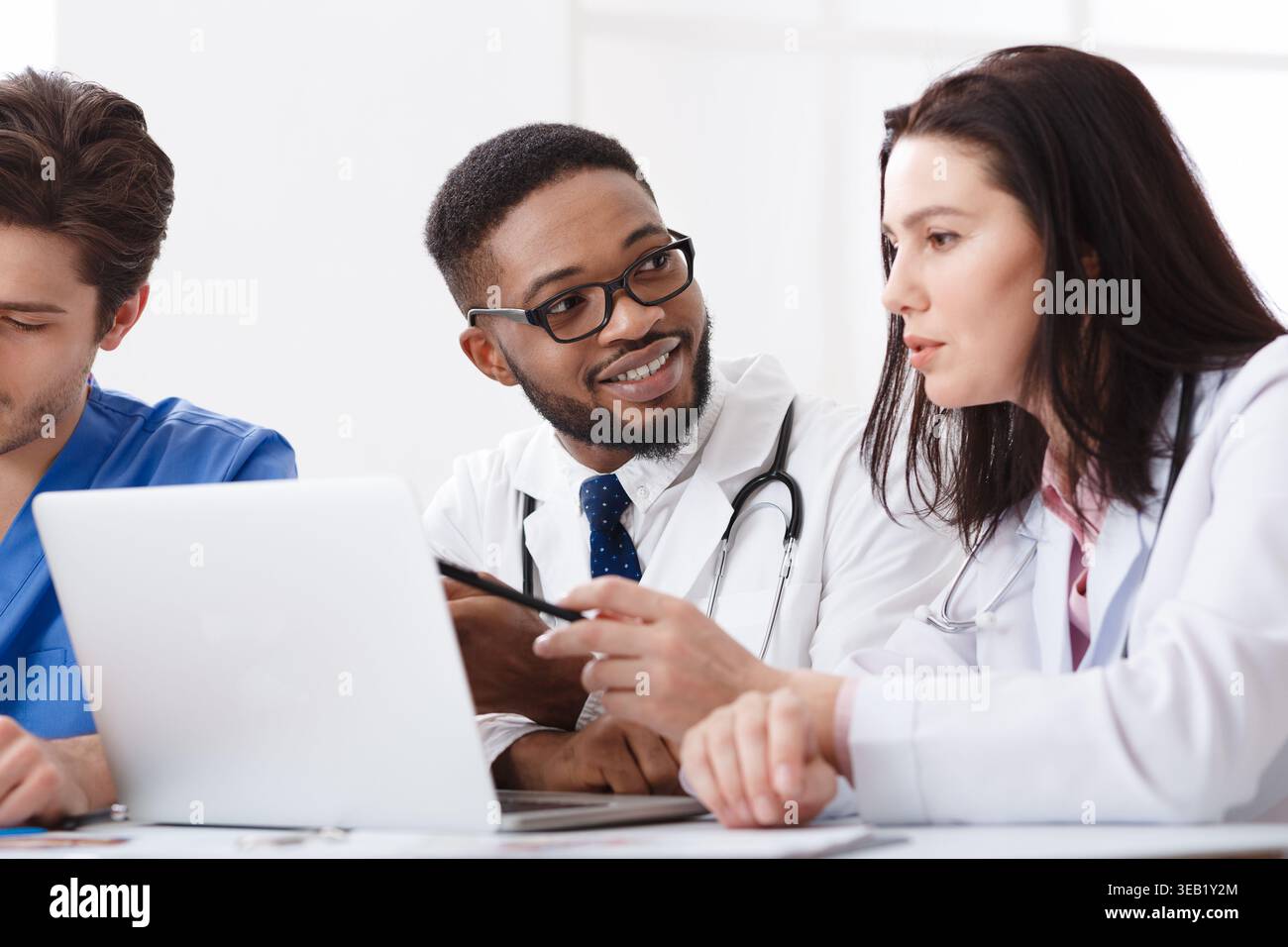 Due medici consulenza, utilizzando laptop in ufficio Foto Stock