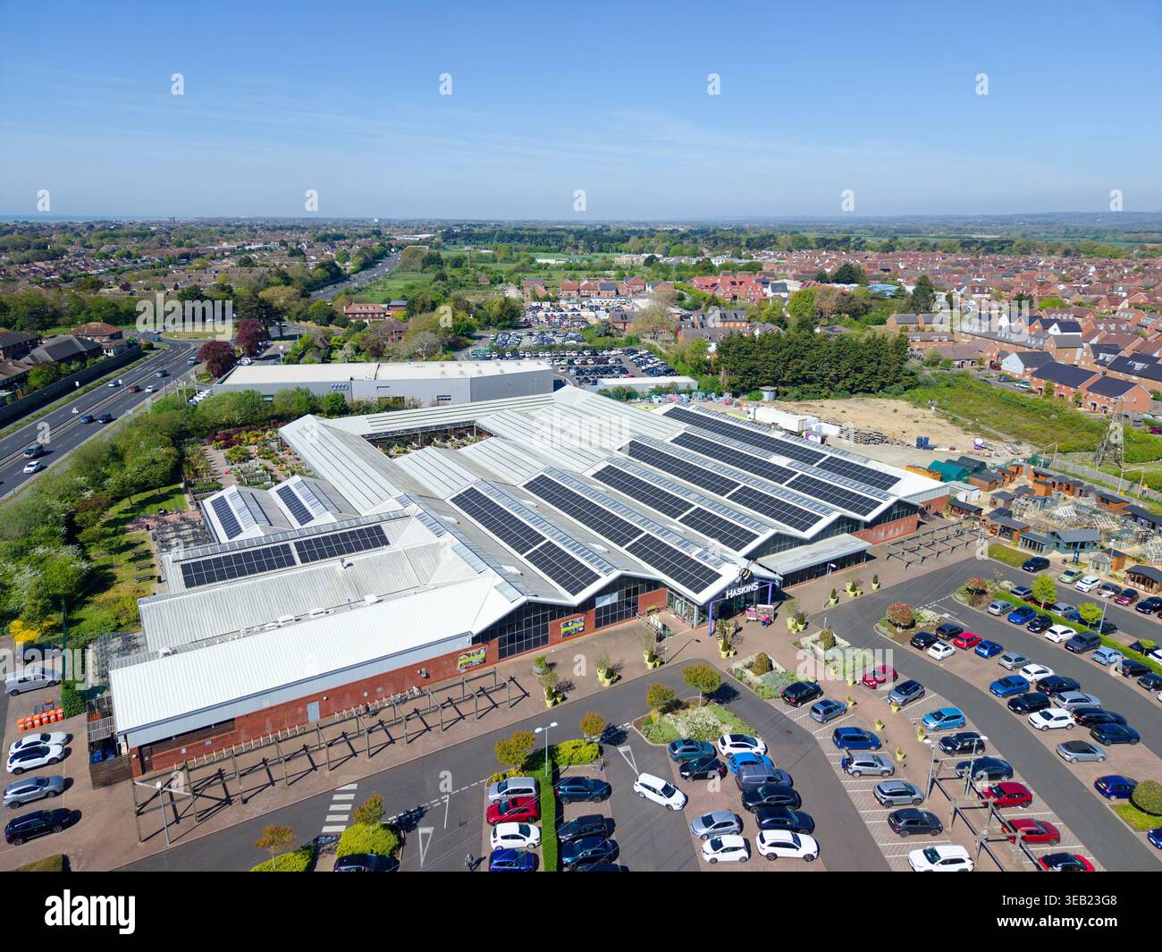 Moderno centro giardino Haskins a Roundstone, Angmering, con pannelli solari sul tetto per l'energia verde e parcheggio auto, all'uscita della A259 nel West Sussex, Regno Unito. Foto Stock