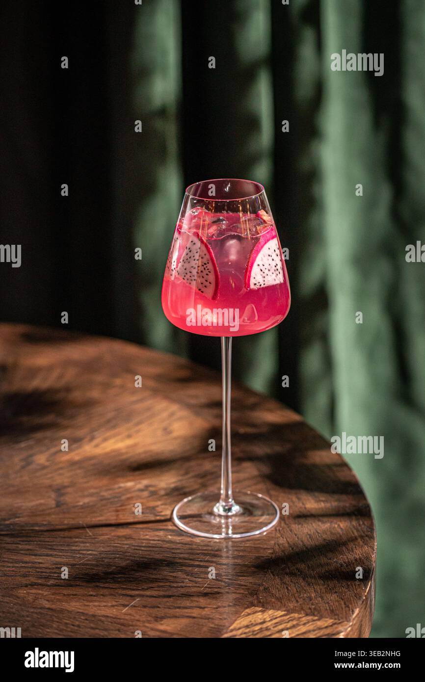 Cocktail rosa con frutta di drago in bicchiere di vino Foto Stock