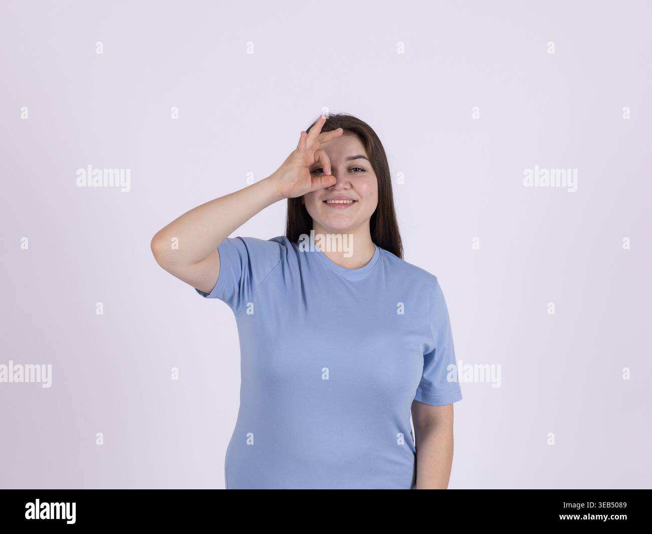 Donna che fa un gesto circolare con le dita vicino agli occhi Foto Stock