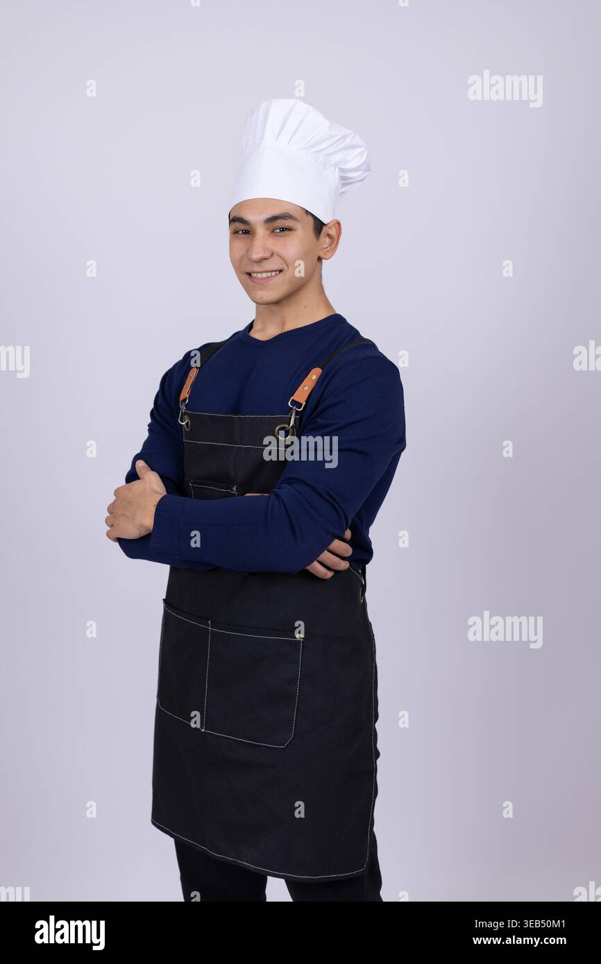 Chef maschile in uniforme nera e cappello bianco Foto Stock