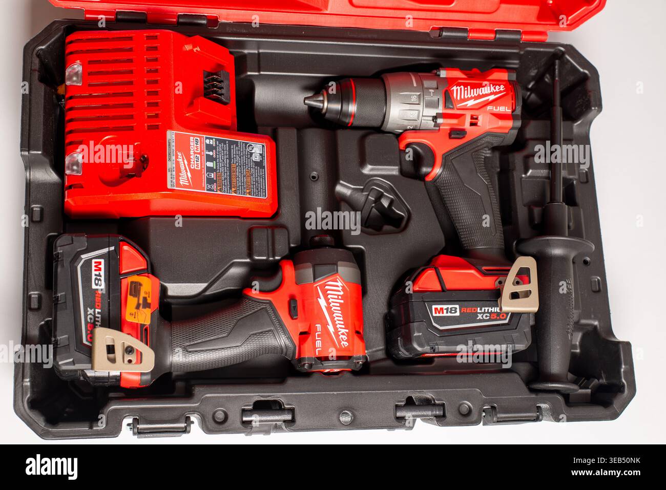 Chicago, il, USA – 12 dicembre 2025: Kit avvitatore a percussione e trapano cordless Milwaukee con batterie e caricabatterie in custodia Foto Stock