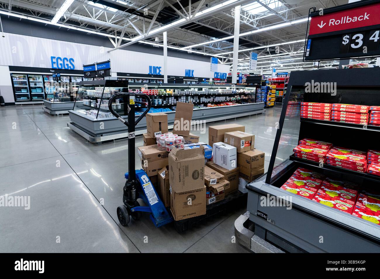 Interno del Walmart Supercenter con presa per pallet carica di scatole nella scena operativa Active Sales Floor Aisle Foto Stock