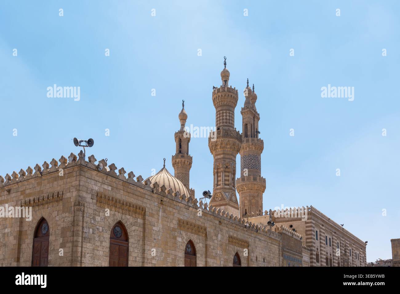 Vista della Moschea al-Azhar con i suoi minareti in pietra ornati e la cupola centrale sotto un cielo azzurro cristallino a El-DARB El-Ahmar, Governatorato del Cairo, Egitto. Foto Stock