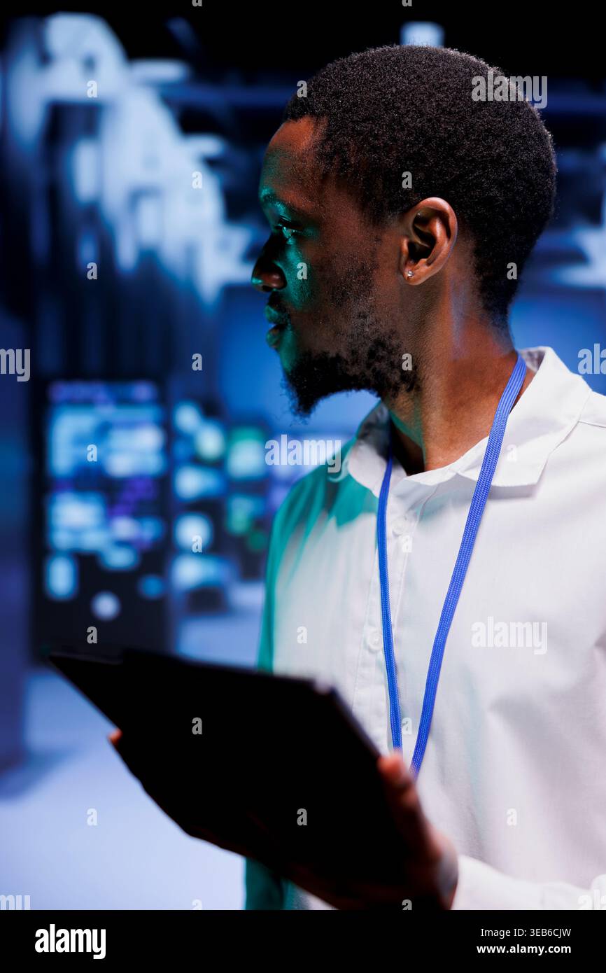 Tecnico nell'hub server che configura server di gioco Internet multigiocatore dedicati ad alta larghezza di banda per gestire più traffico da sedi in tutto il mondo, evitare tempi di ritardo dirompenti e bassi tassi di ping Foto Stock