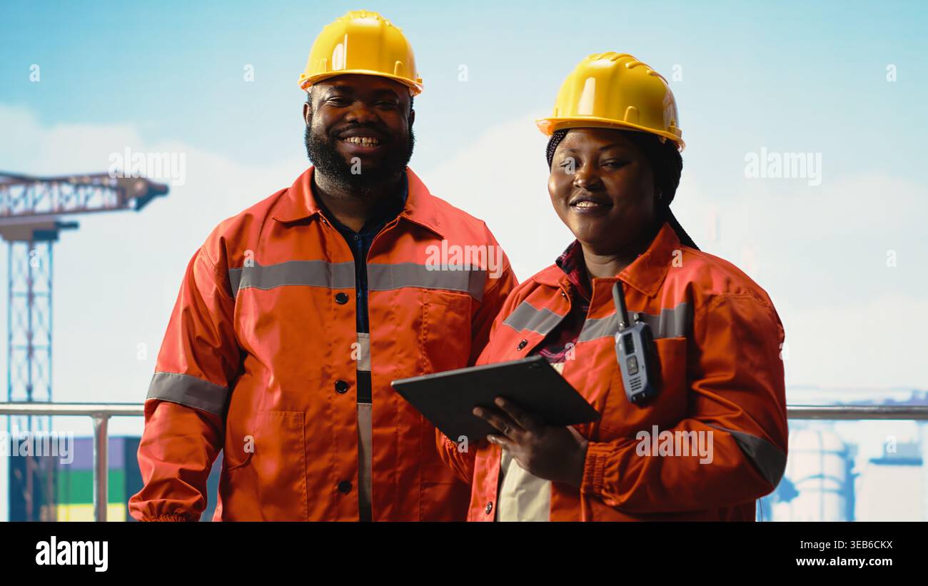 Felice team di progettazione della piattaforma offshore che monitora le operazioni sulla chiatta per la produzione di petrolio. Gioioso carro di perforazione equipaggio di navi che indossa attrezzature di sicurezza che riesaminano le operazioni energetiche Foto Stock