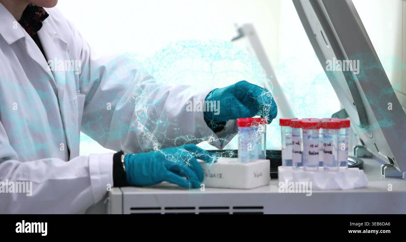 Manipolazione di tecnici da laboratorio con camice bianco e guanti di colore verde acqua utilizzando strumenti da banco, con rack di fiale con tappo rosso Foto Stock