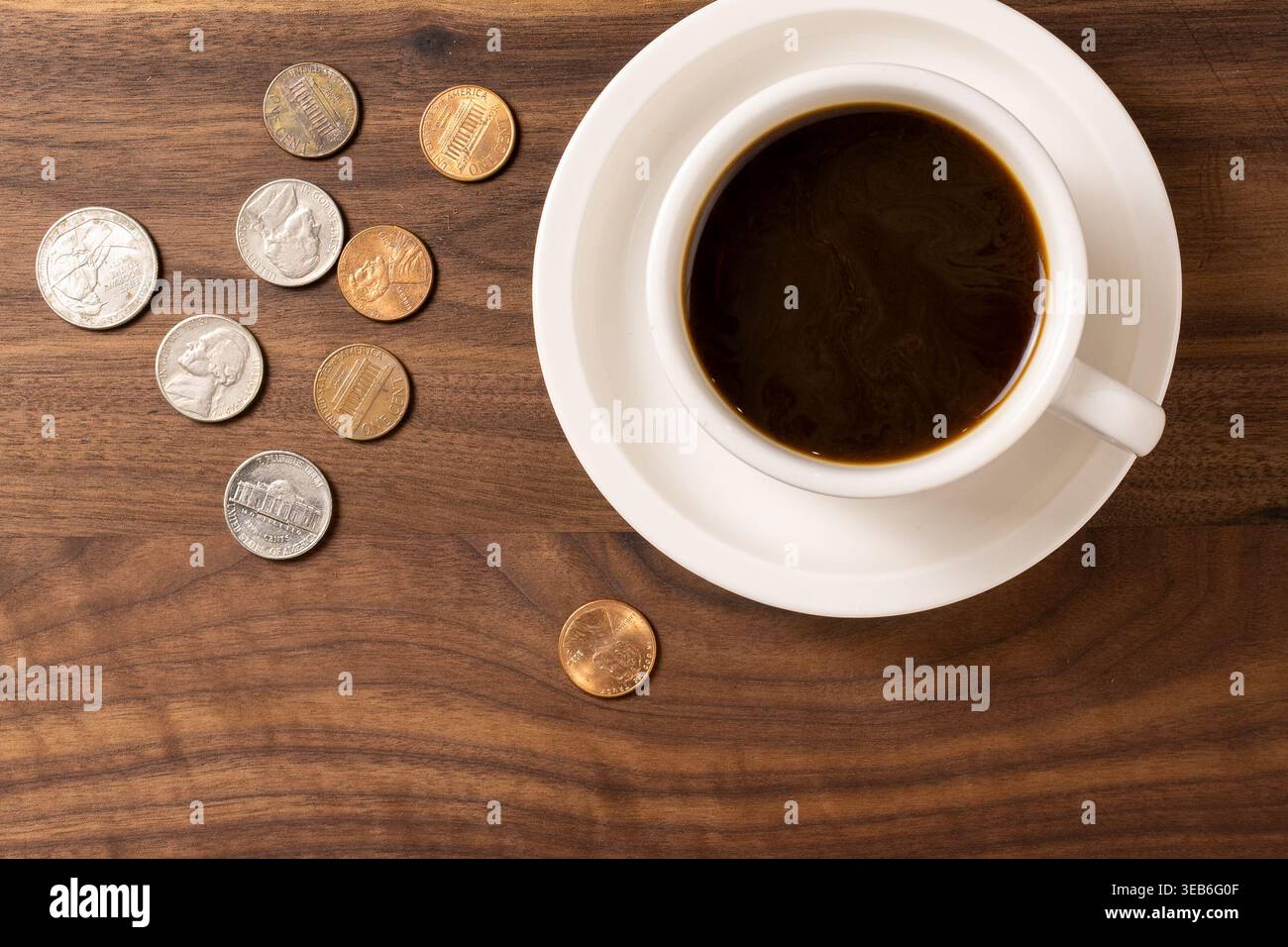 Tazza di caffè su una superficie in legno con cambio libero – concetto di spesa quotidiana Foto Stock