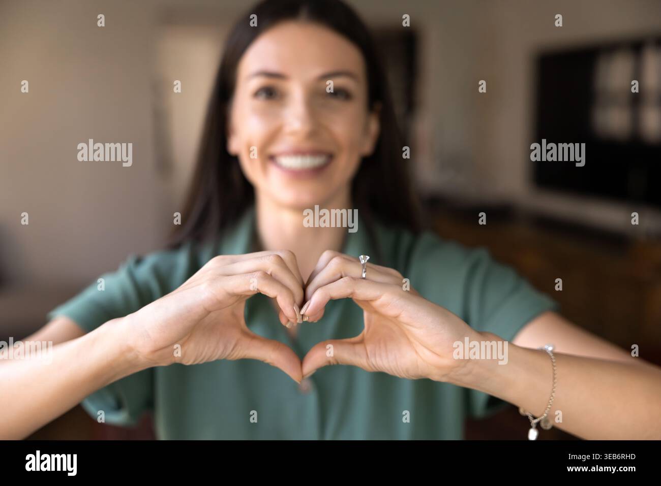 Donna che fa gesti cardiaci con le mani a casa, primo piano Foto Stock
