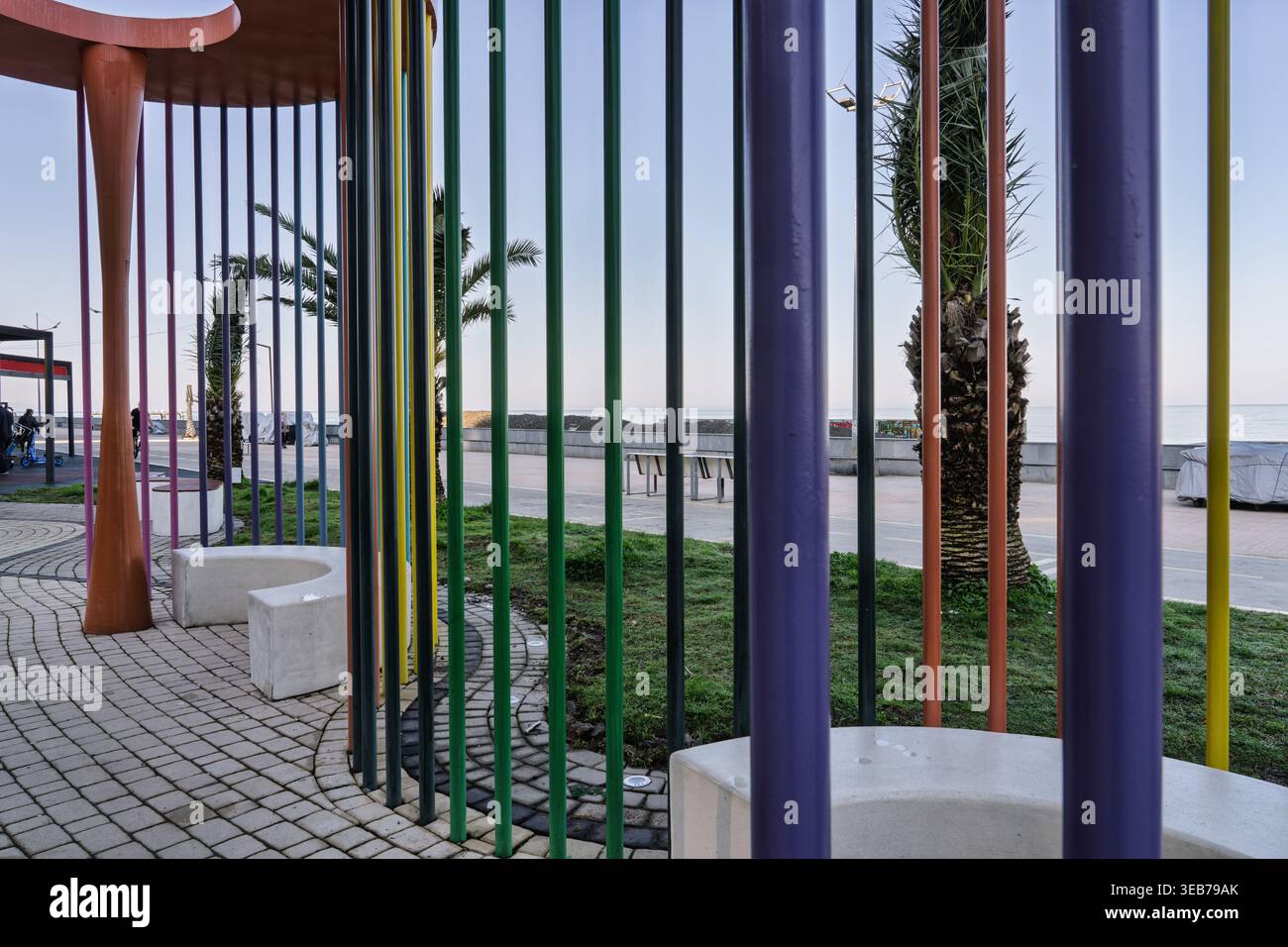 Batumi, georgia, 21 aprile 2026: Moderno design urbano lungo il viale batumi caratterizzato da pali colorati che forniscono ombra e posti a sedere con vista sulla S nera Foto Stock