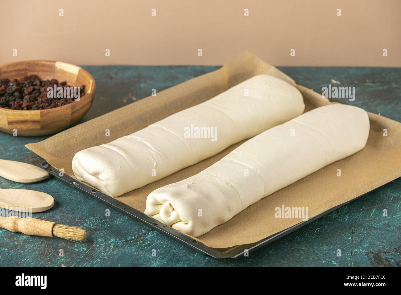 Due strudels non cotti, arrotolati su un vassoio da forno con carta da forno Foto Stock