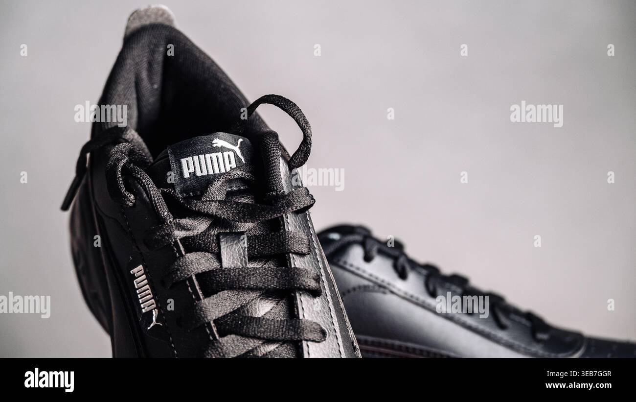 Lettonia, Jurmala, 12.04.2026: Sneakers Puma nere mostrate in dettaglio con particolare attenzione ai lacci e al logo su uno sfondo chiaro durante una messa in scena in studio Foto Stock