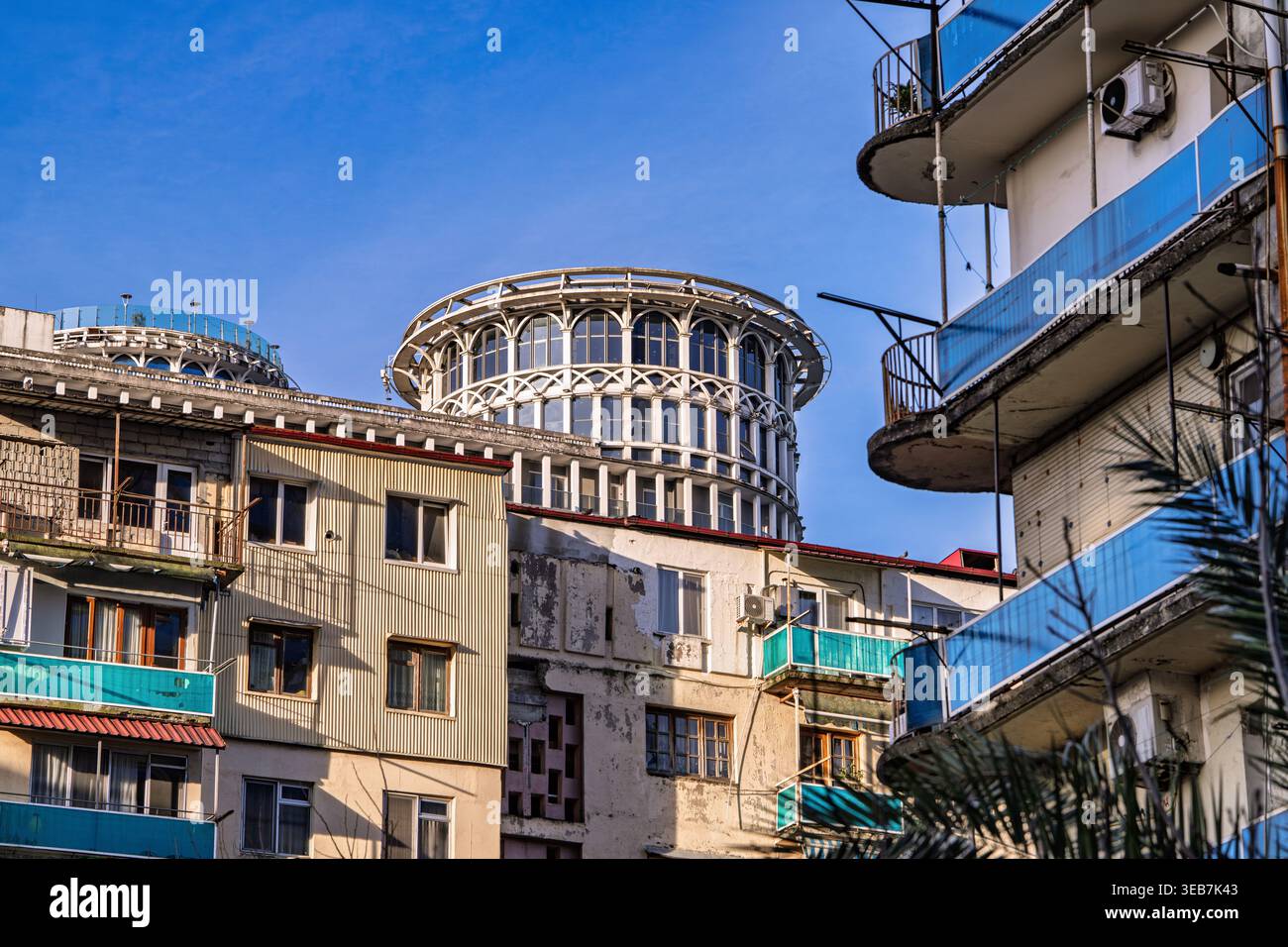 Batumi, georgia, 21 aprile 2026: Vecchi edifici residenziali a batumi in contrasto con un edificio moderno e ornato che mostra lo sviluppo architettonico urbano Foto Stock