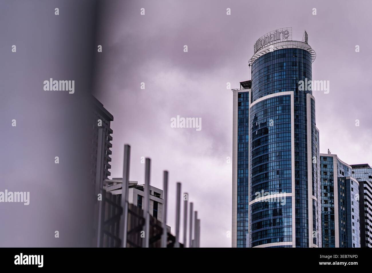 Batumi, georgia 21 aprile 2026: Moderno grattacielo con una facciata in vetro curvo che riflette il cielo nuvoloso di batumi, georgia. Rappresenta lo sviluppo urbano Foto Stock
