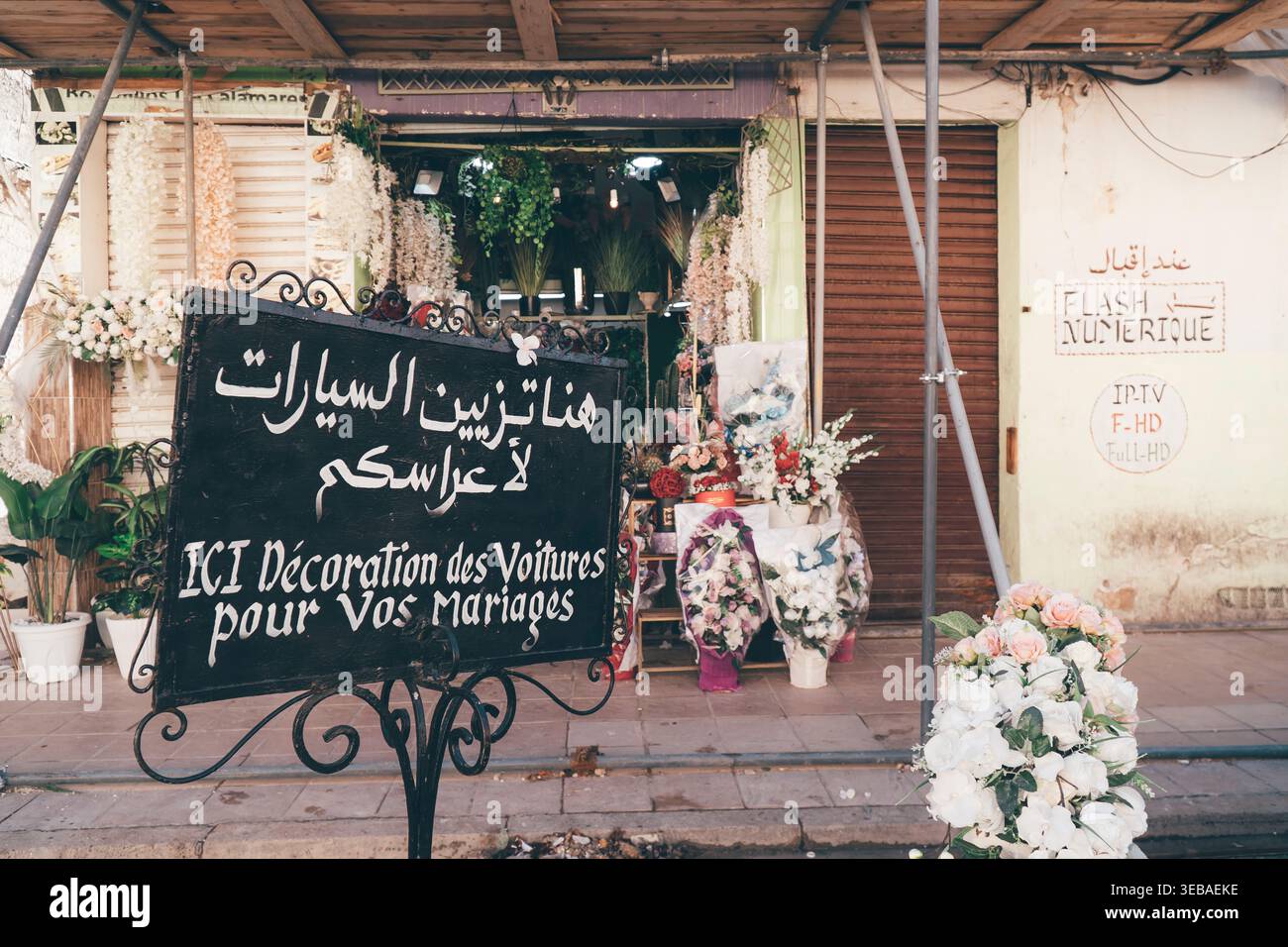 Affascinanti vicoli marocchini con vivaci negozi di fiori, persiane intemprate e architettura rustica. Uno sguardo alla bellezza nascosta della Medina Foto Stock