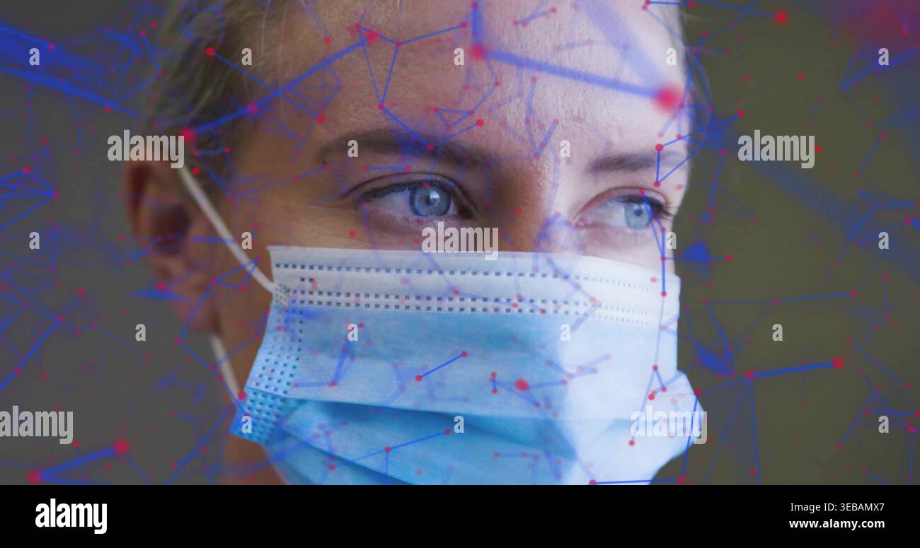 Donna che indossa una maschera chirurgica azzurra rivolta verso destra in ambienti interni con sovrapposizione a nodo rosso con linea blu Foto Stock