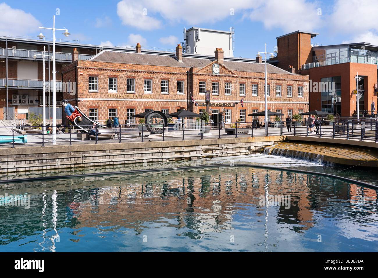 L'Old Customs House di Portsmouth è un pub e ristorante classificato Grade i a Gunwharf Quays, qui riflesso nell'acqua in un giorno primaverile. REGNO UNITO Foto Stock