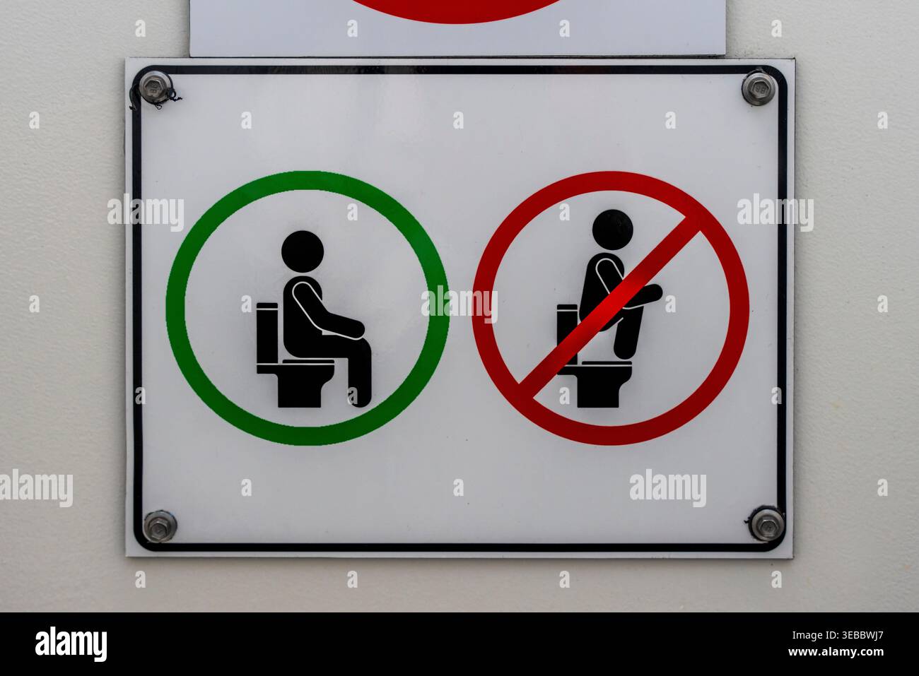 Un cartello in un lavatorio di Auckland istruisce alcuni turisti asiatici su come usare Un "WC occidentale", Auckland, nuova Zelanda. Foto Stock