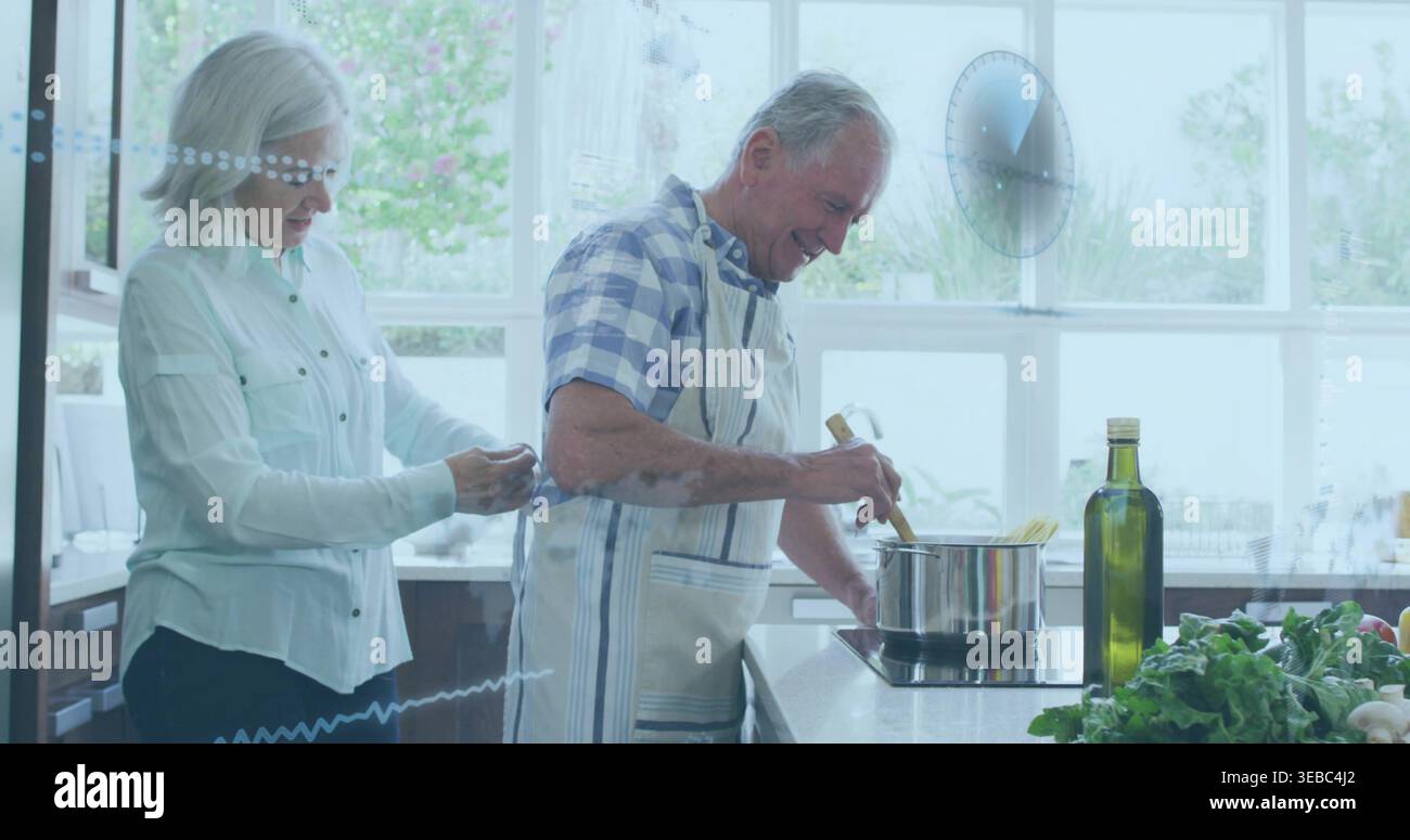 Un uomo che mescola il grembiule con la pentola in cucina, una donna in camicetta con bottoni che legano il grembiule dietro di lui Foto Stock
